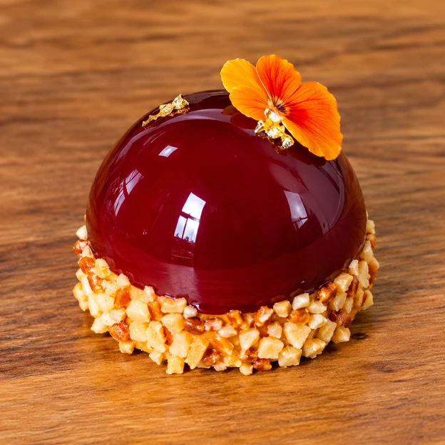 Entremet glace aux fruits rouges, eclats de praline et capucine