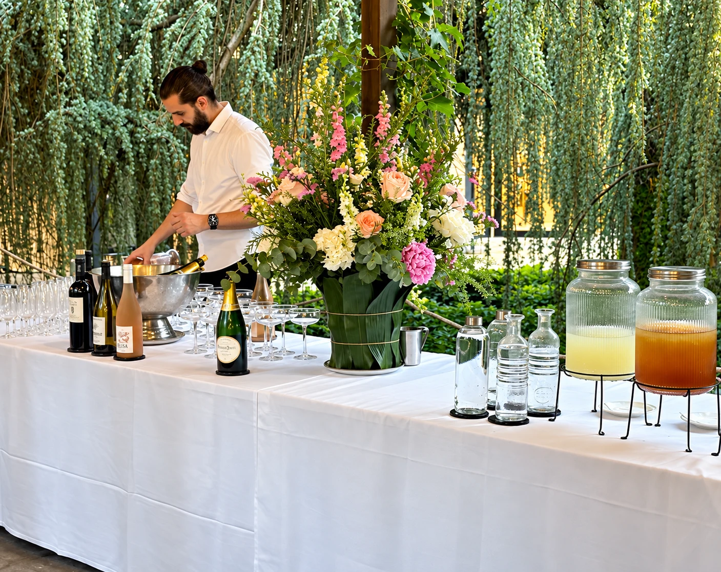 Service au bar, champagne et composition florale sous le saule