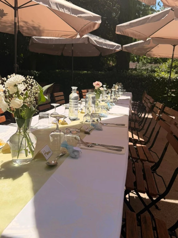 Table dressee en terrasse sous les parasols, bouquets de saison